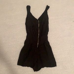 Black romper with gold zipper detail